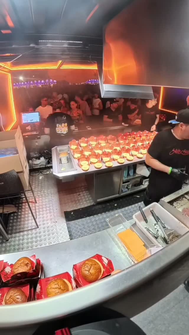 Smash burgers lined up on the pass at Sexto Sentido